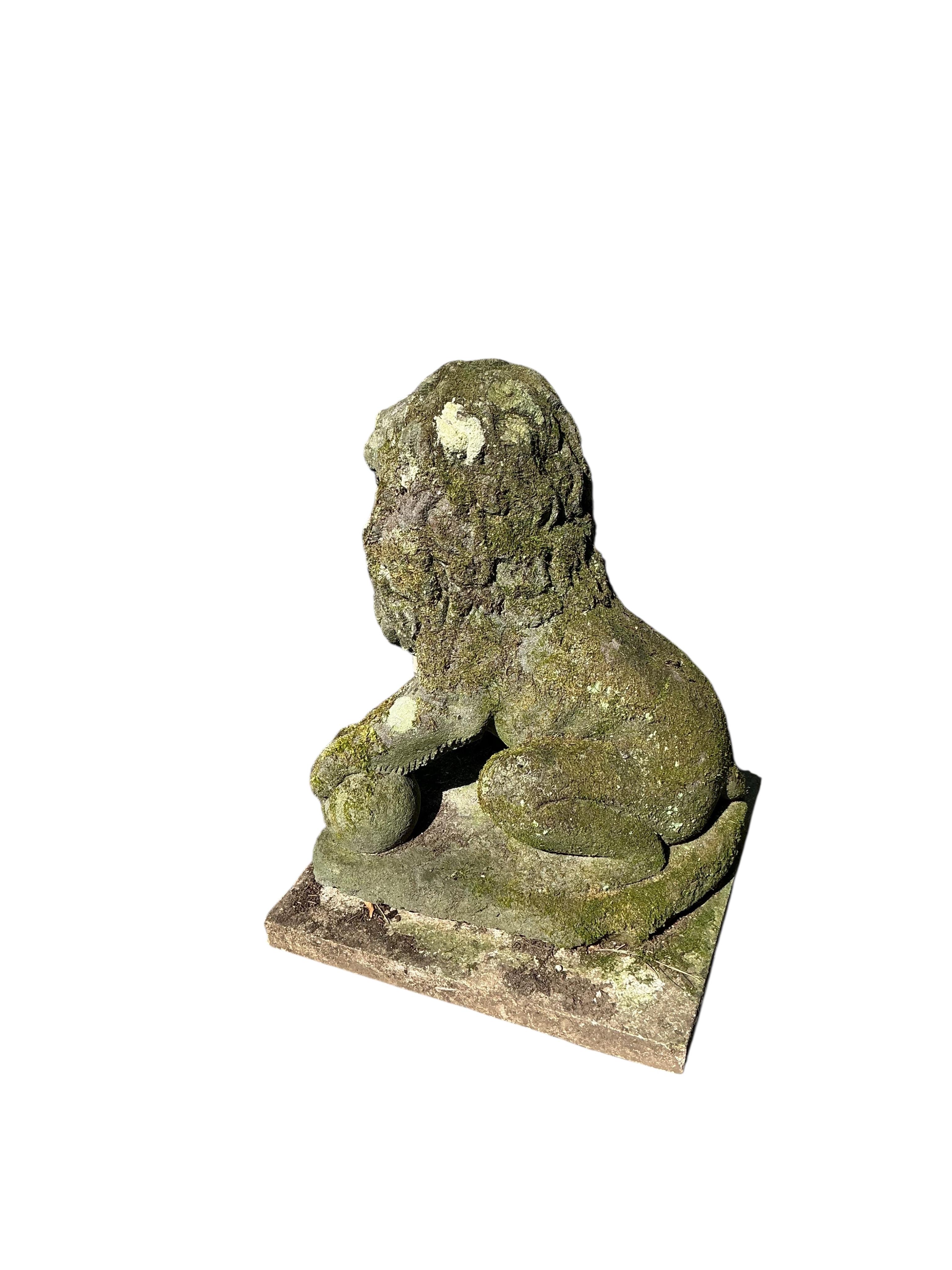 A reconstituted stone seated lion garden ornament, height 60cm